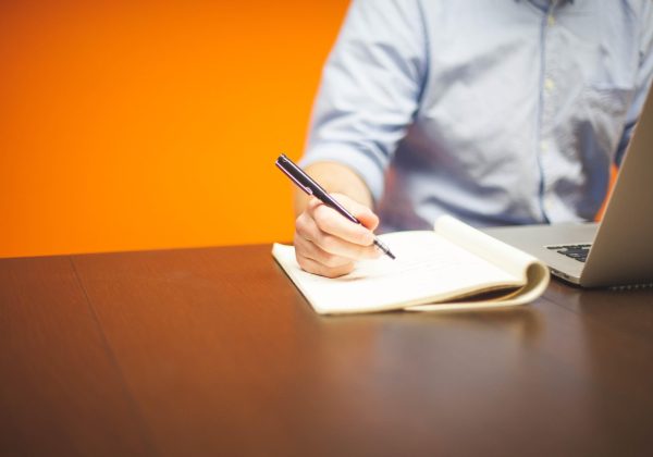 职场人士在笔记本电脑前使用 wps ai 写作助手生成工作报告初稿，暖色调办公室环境，专注投入